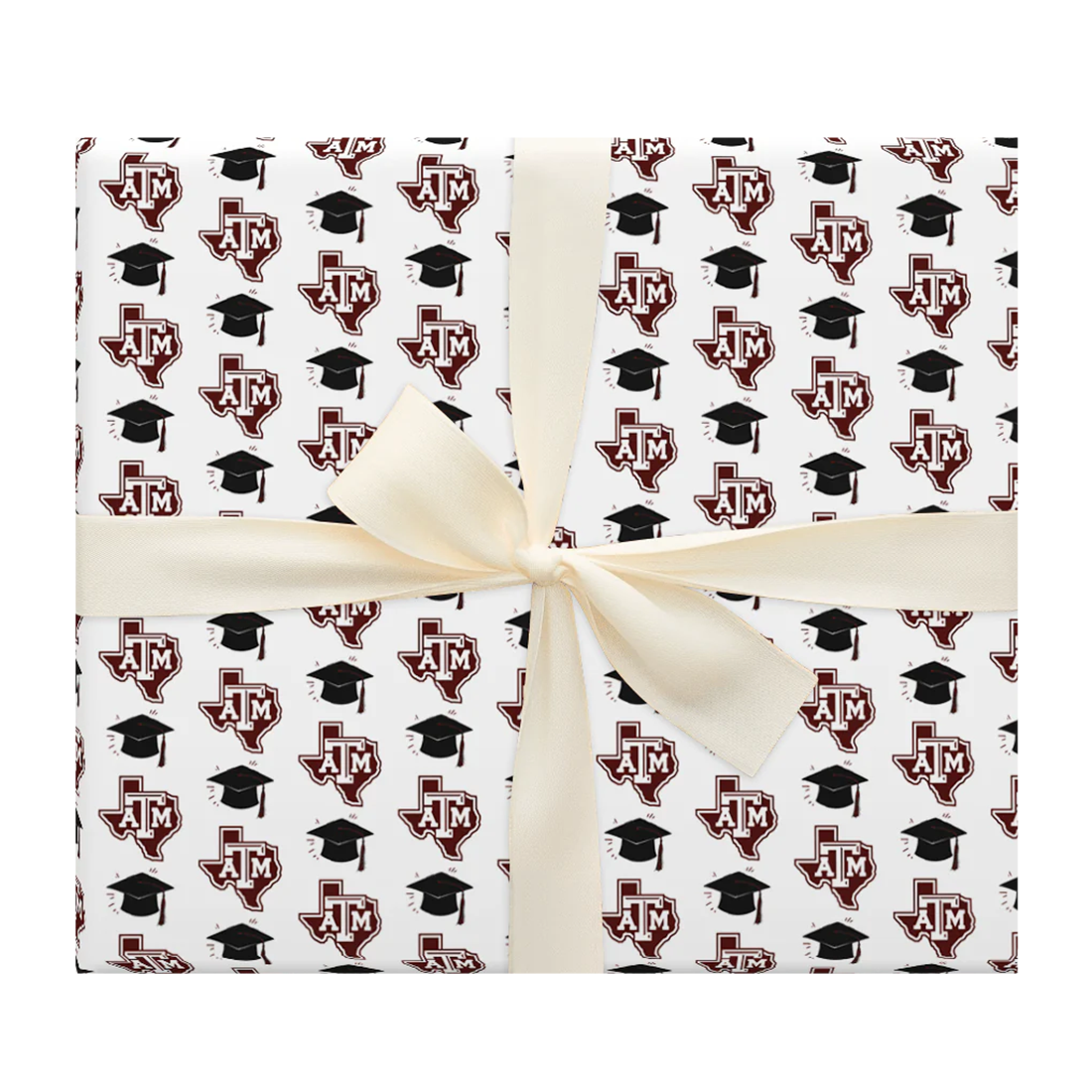 White wrapping paper with graduation caps in black and the lone-star Texas A&M emblem all over the paper.