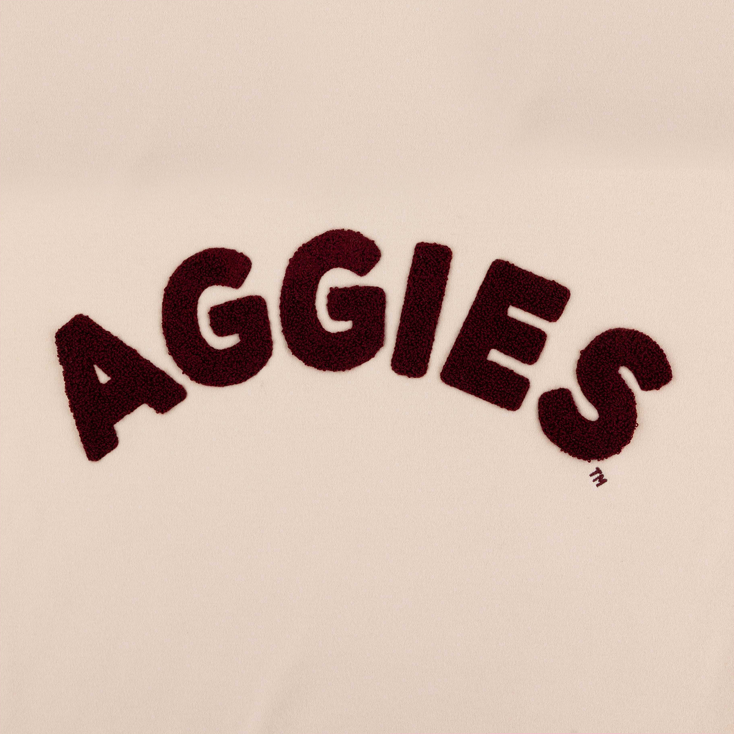 lose-up of maroon chenille AGGIES arch graphic on oatmeal sweatshirt