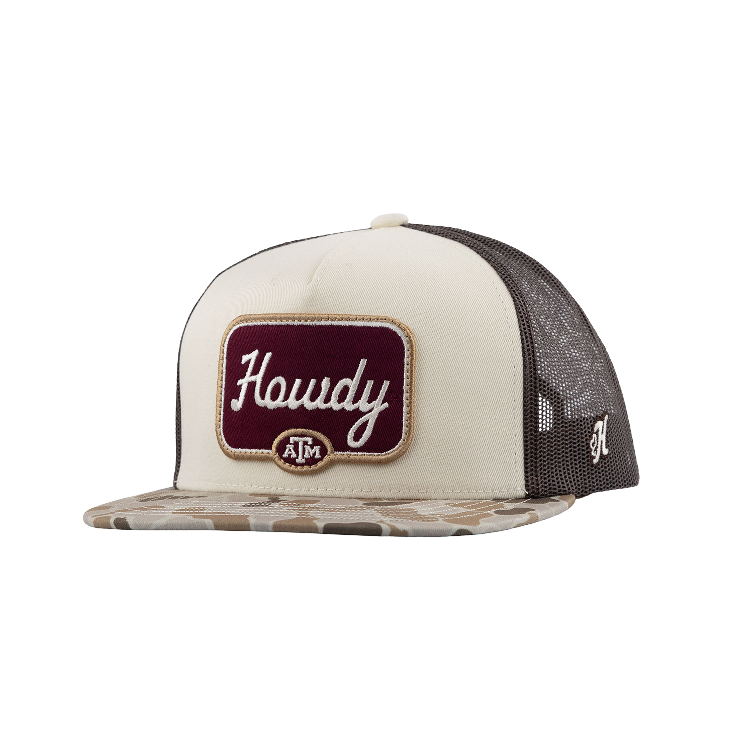 A trucker-style cap with a cream front panel, dark gray mesh back, and a camouflage-patterned flat brim. The front features a maroon patch with white script reading 'Howdy' and a small circular 'A&M' logo below it.