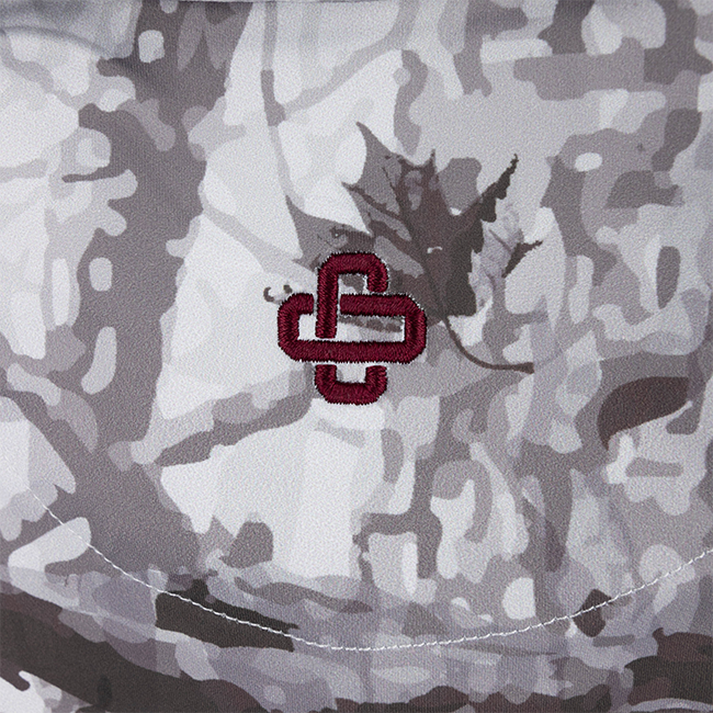 Zoomed in maroon branding logo on woodlands camo polo