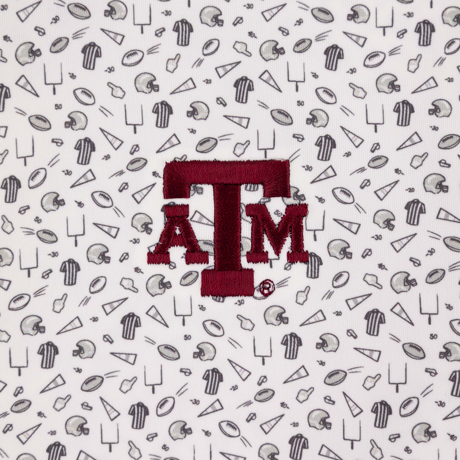 close up of maroon ATM logo from all over youth polo