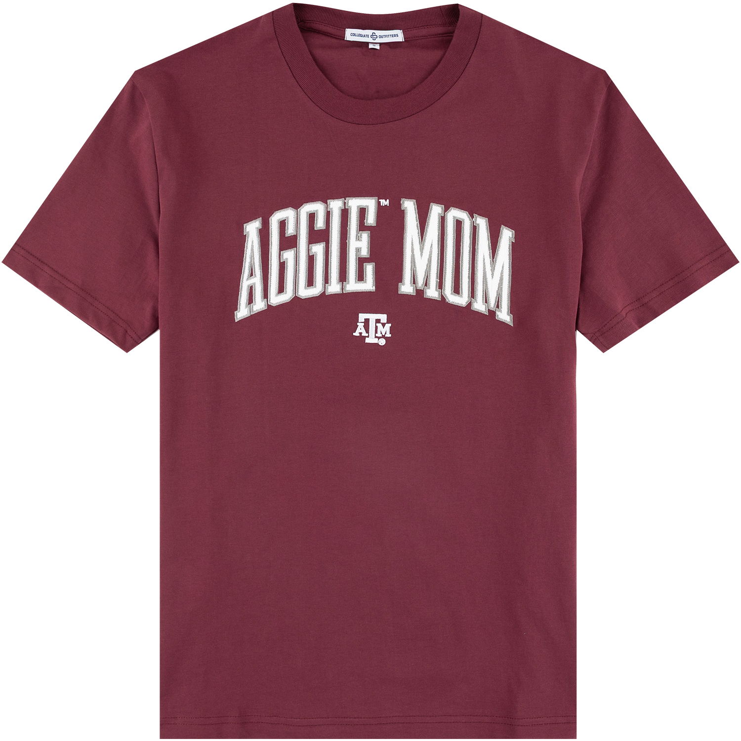 Maroon short-sleeved t-shirt featuring "AGGIE MOM" in arched white varsity block letters across the chest, centered above the Texas A&M primary logo.   