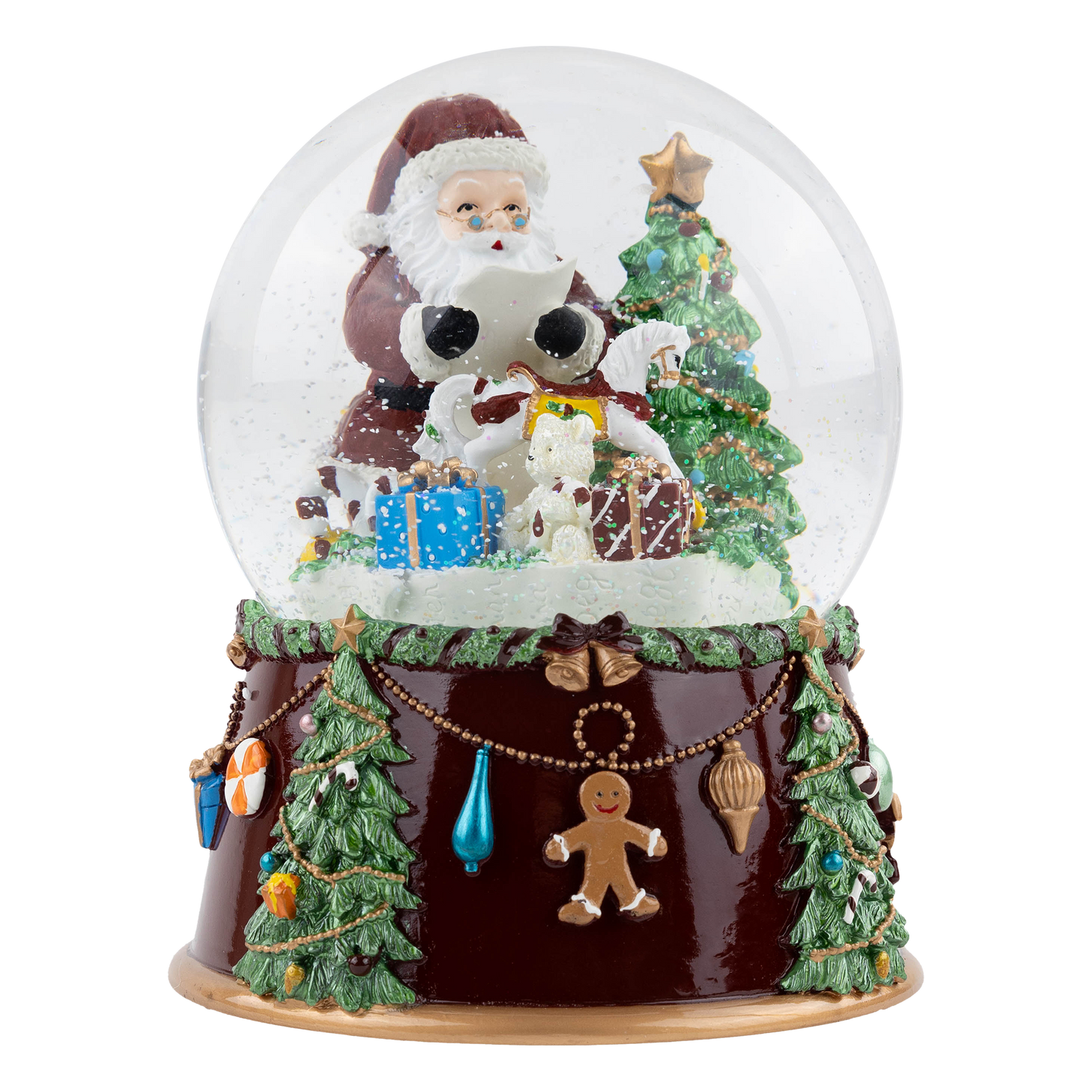 Decorative Christmas snow globe featuring Santa holding a songbook beside a decorated Christmas tree, a white rocking horse, and wrapped presents, with falling snow and a dark brown base adorned with miniature Christmas trees, ornaments, gingerbread men, and holiday garland.