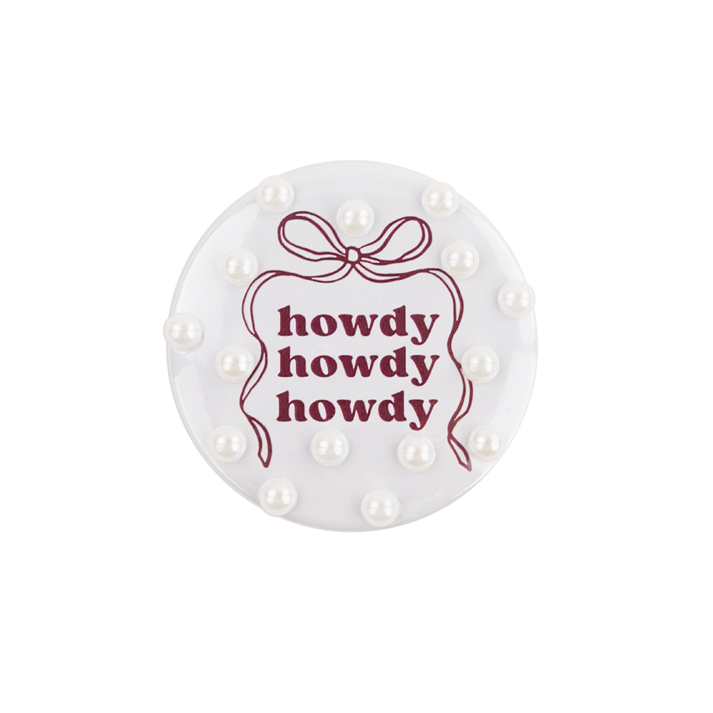 Round white buttin with 'howdy' text and decorative bow