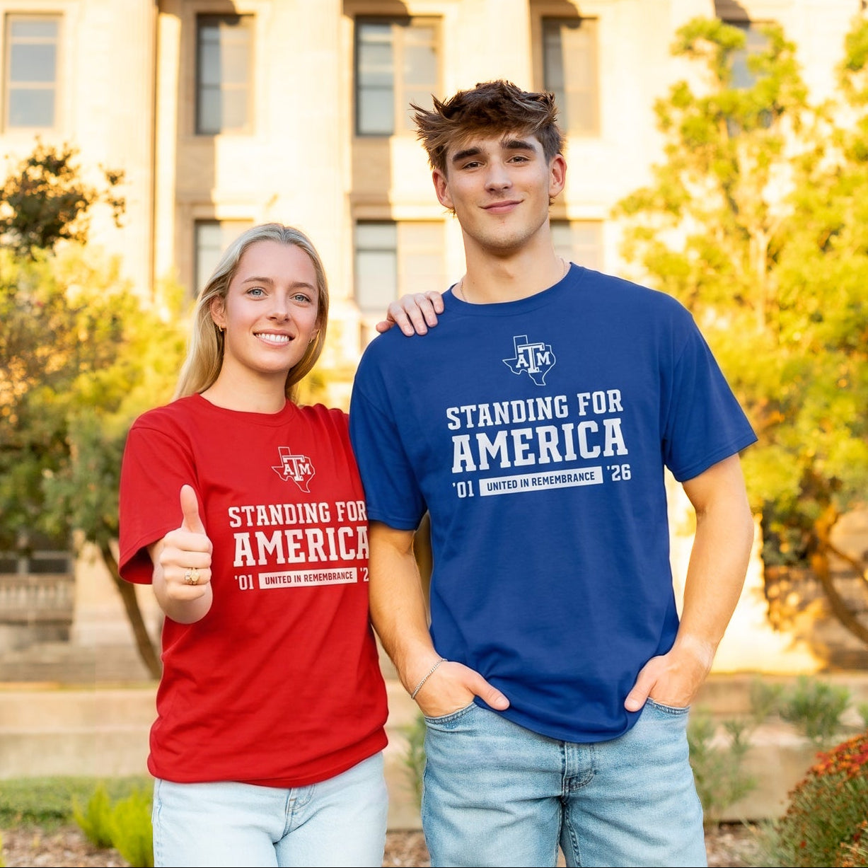 Two students standing in front of a neoclassical domed building, wearing matching red and blue t-shirts that read 'STANDING FOR AMERICA' with the A&M logo.