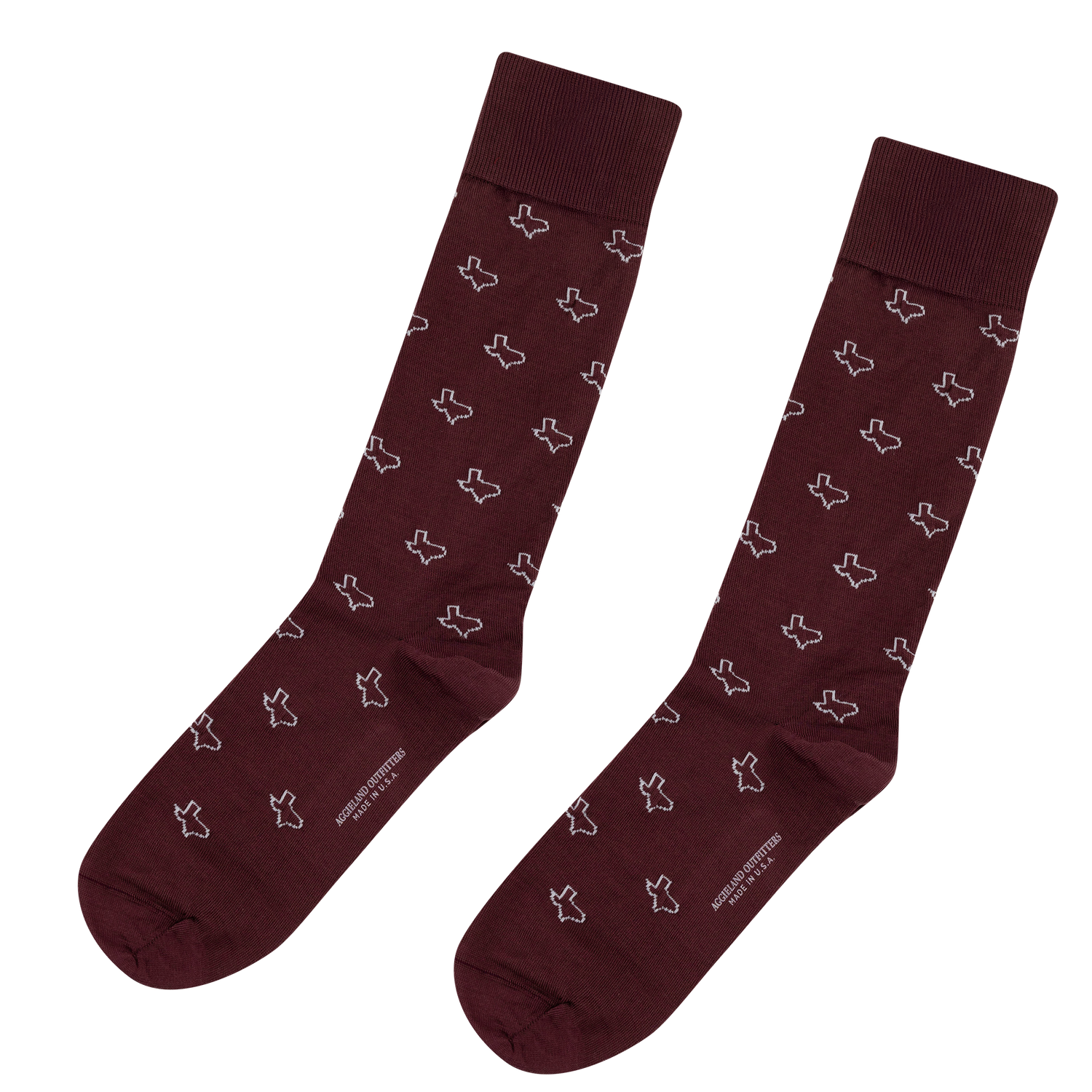 Pair of maroon crew socks with a repeating white state of Texas outline pattern, featuring "AGGIELAND OUTFITTERS MADE IN U.S.A." printed along the sole.   
