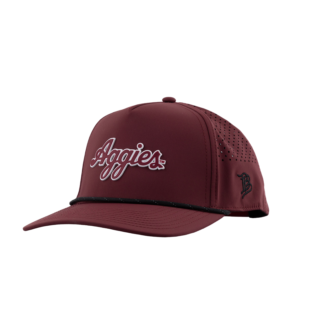 A maroon baseball cap with 'Aggies' embroidered in white and red script on the front, featuring a curved brim, perforated side panels, and a black embroidered 'B' logo on the side.