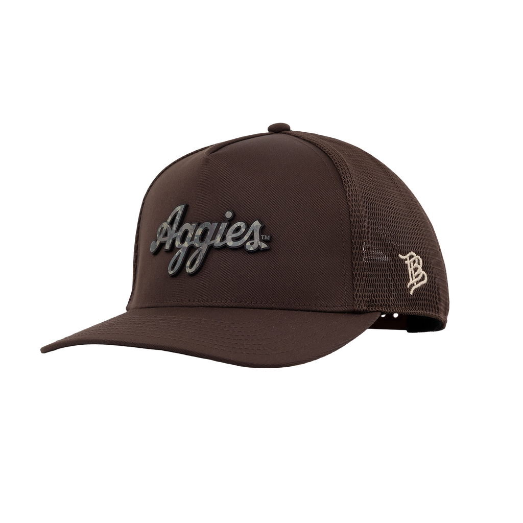 A dark brown trucker-style baseball cap with a curved brim, featuring a script 'Aggies' camo patch on the front and a small cream-colored 'B' logo on the side mesh back, shown against a plain white background.