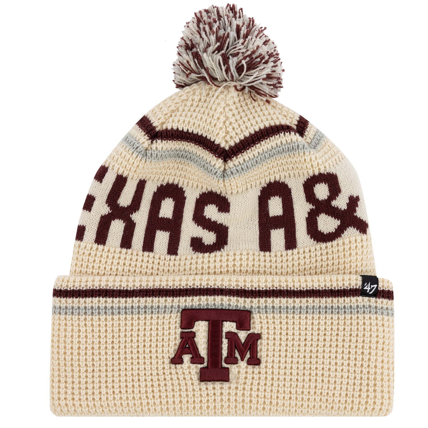An off-white Texas A&M knit pom beanie featuring maroon lettering across the front and an embroidered ATM logo on the folded cuff.   