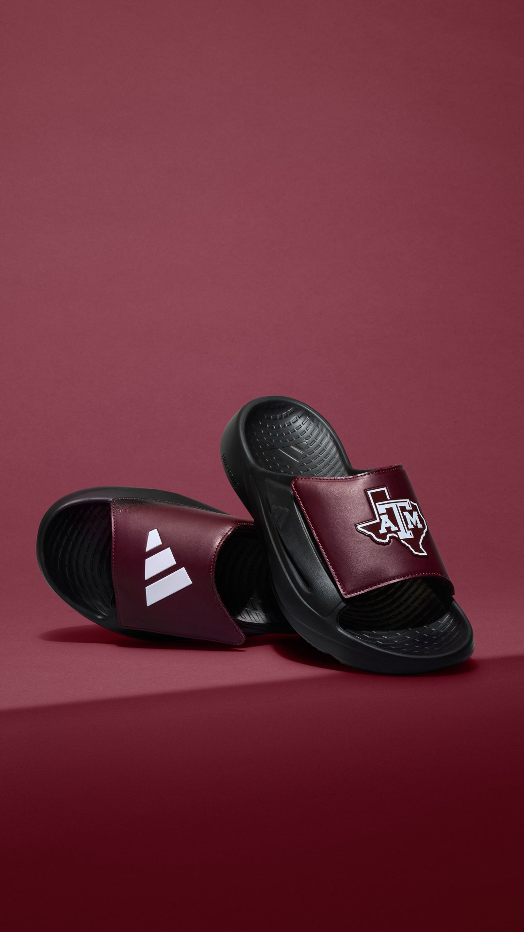 Pair of maroon and black slides with the Texas A&M lone-star design and the Adidas logo in white