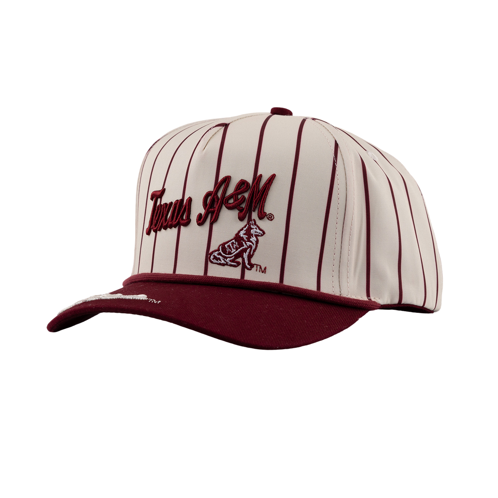 Cream and maroon Texas A&M snapback cap with pinstripe pattern, script "Texas A&M" logo, and Reveille mascot embroidery above a maroon brim.