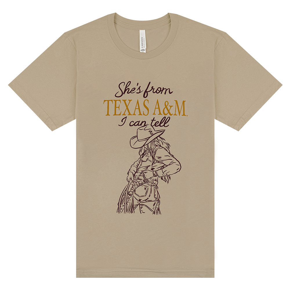 Beige t-shirt with a graphic of a cowgirl and text 'She's from Texas A&M I can tell'