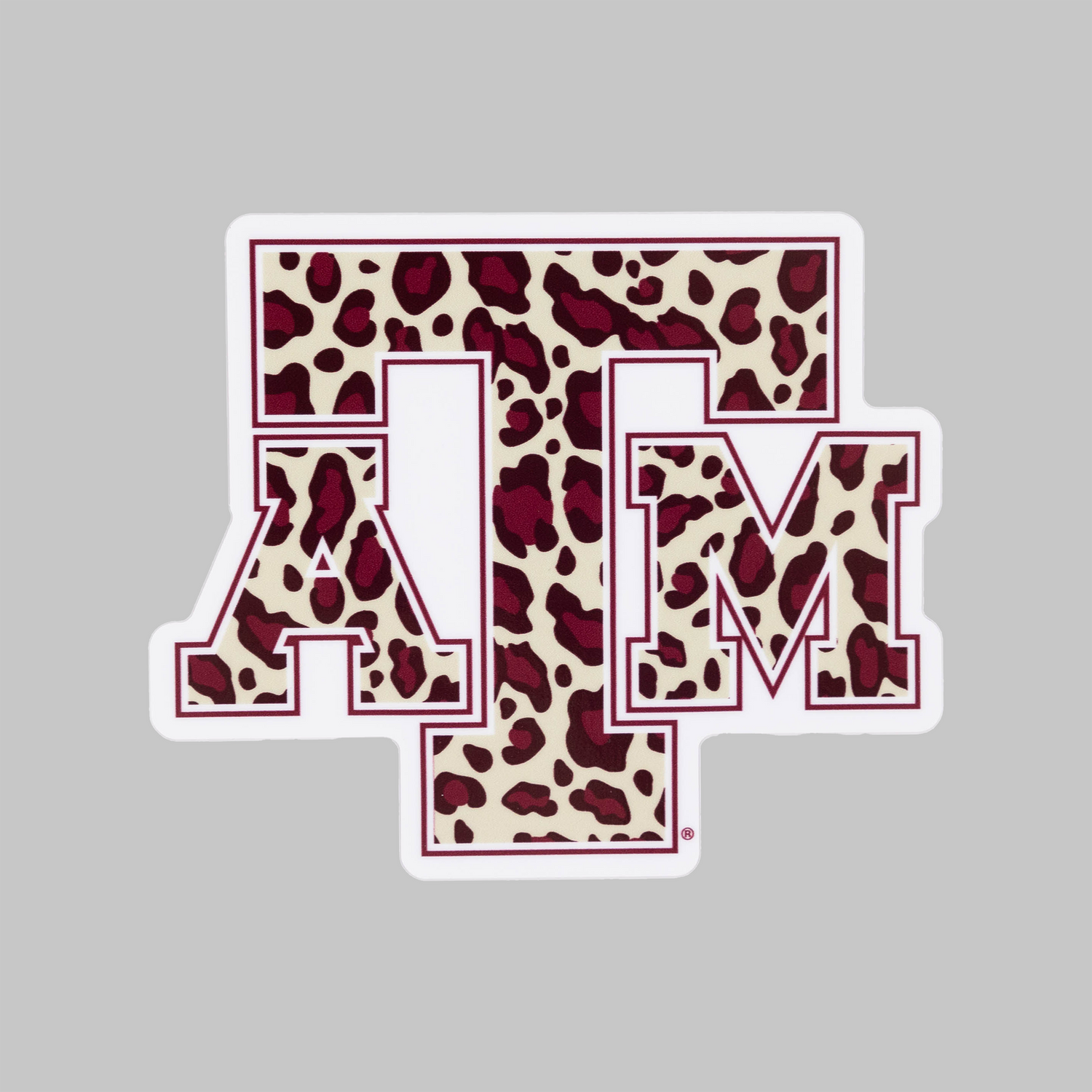 A die-cut sticker featuring the Texas A&M 'A&M' logo filled with a burgundy and beige leopard print pattern, outlined in burgundy with a white border, shown on a solid gray background.