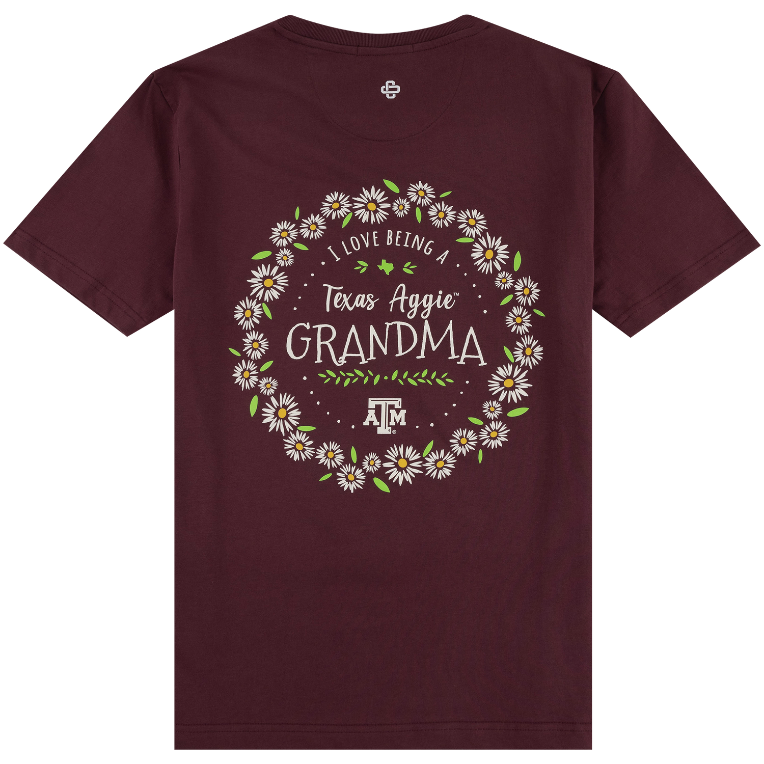 Back of a maroon t-shirt featuring a circular wreath of white and yellow daisies. Inside the floral wreath, white lettering reads "I LOVE BEING A Texas Aggie GRANDMA" above a leafy sprig and the Texas A&M logo.   