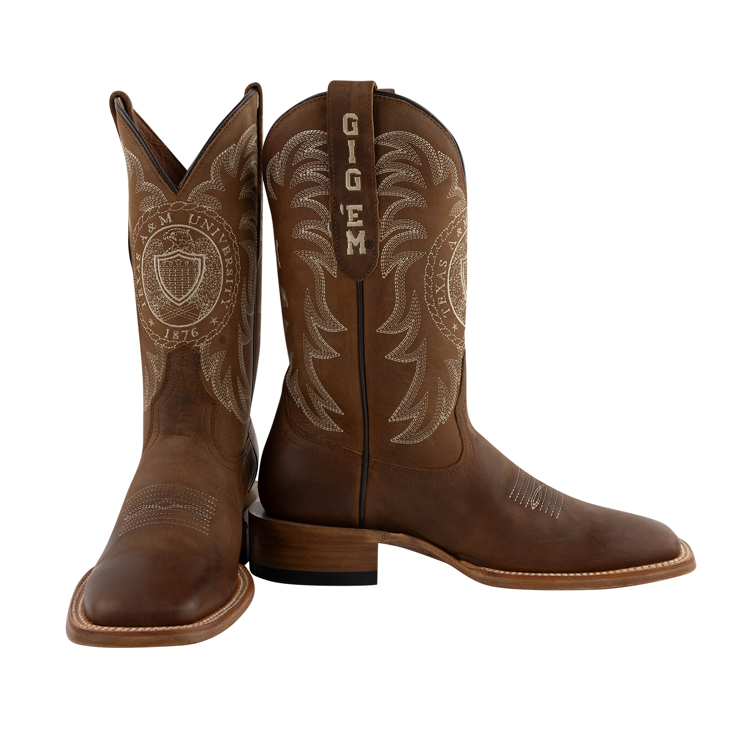 A pair of brown leather cowboy boots with western embroidery and 'GIGEM' branding on the shaft, shown against a plain white background.