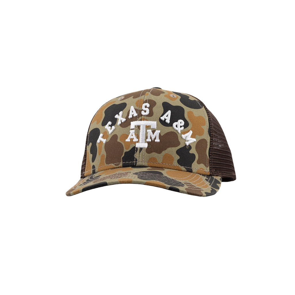 A Texas A&M University trucker hat featuring a tan, brown, and black camouflage pattern on the front panel and brim, with white embroidered 'TEXAS A&M' and 'A&M' logo on the front. The back mesh is dark brown.
