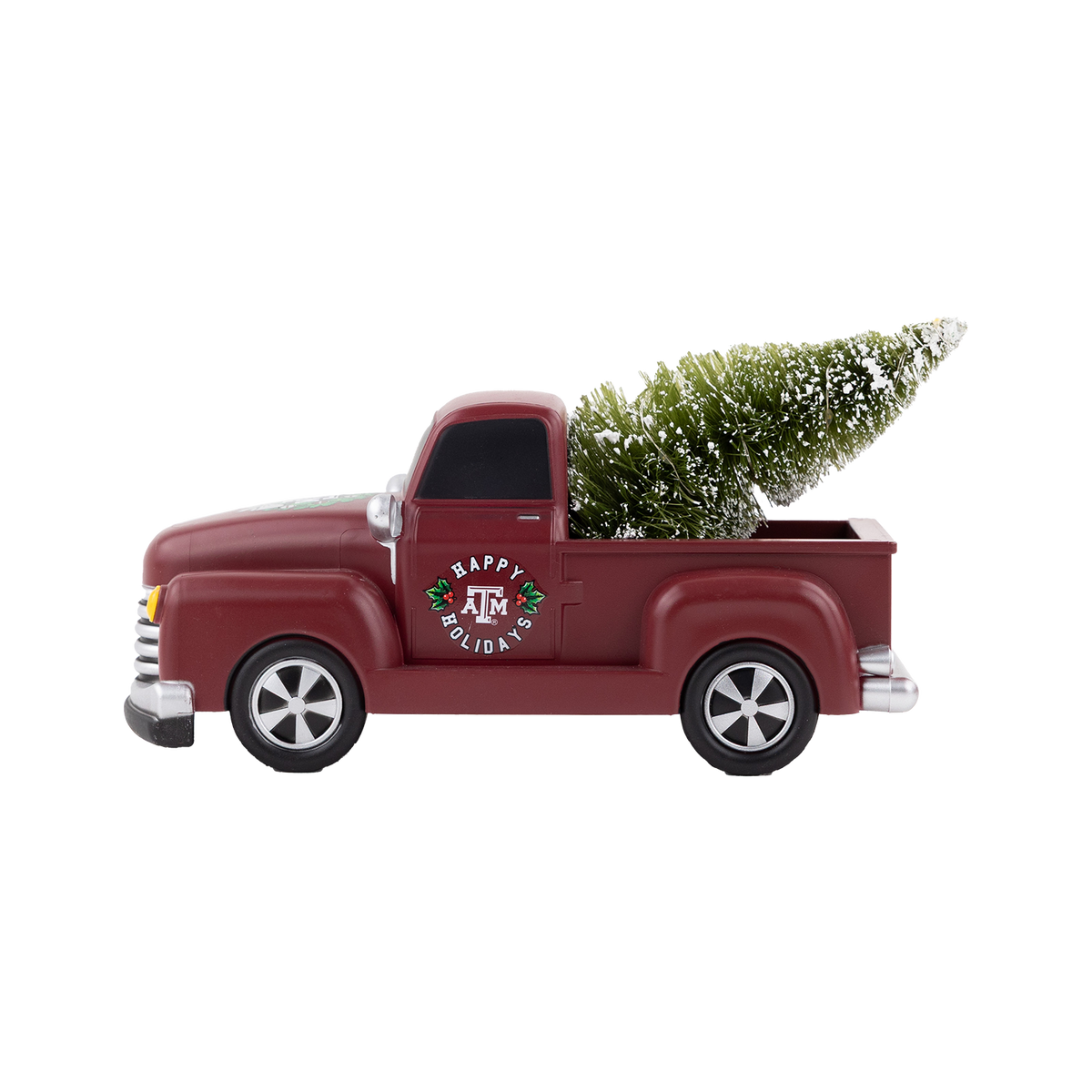 Maroon Texas A&M holiday pickup truck decoration carrying a snow-covered Christmas tree with “Happy Holidays” and the Texas A&M logo on the door.