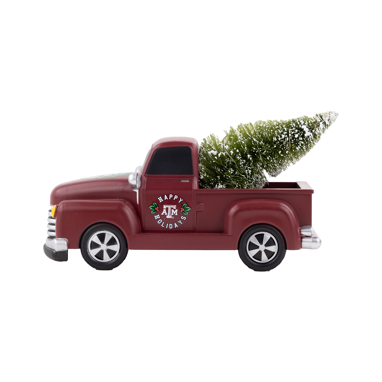 Maroon Texas A&M holiday pickup truck decoration carrying a snow-covered Christmas tree with “Happy Holidays” and the Texas A&M logo on the door.