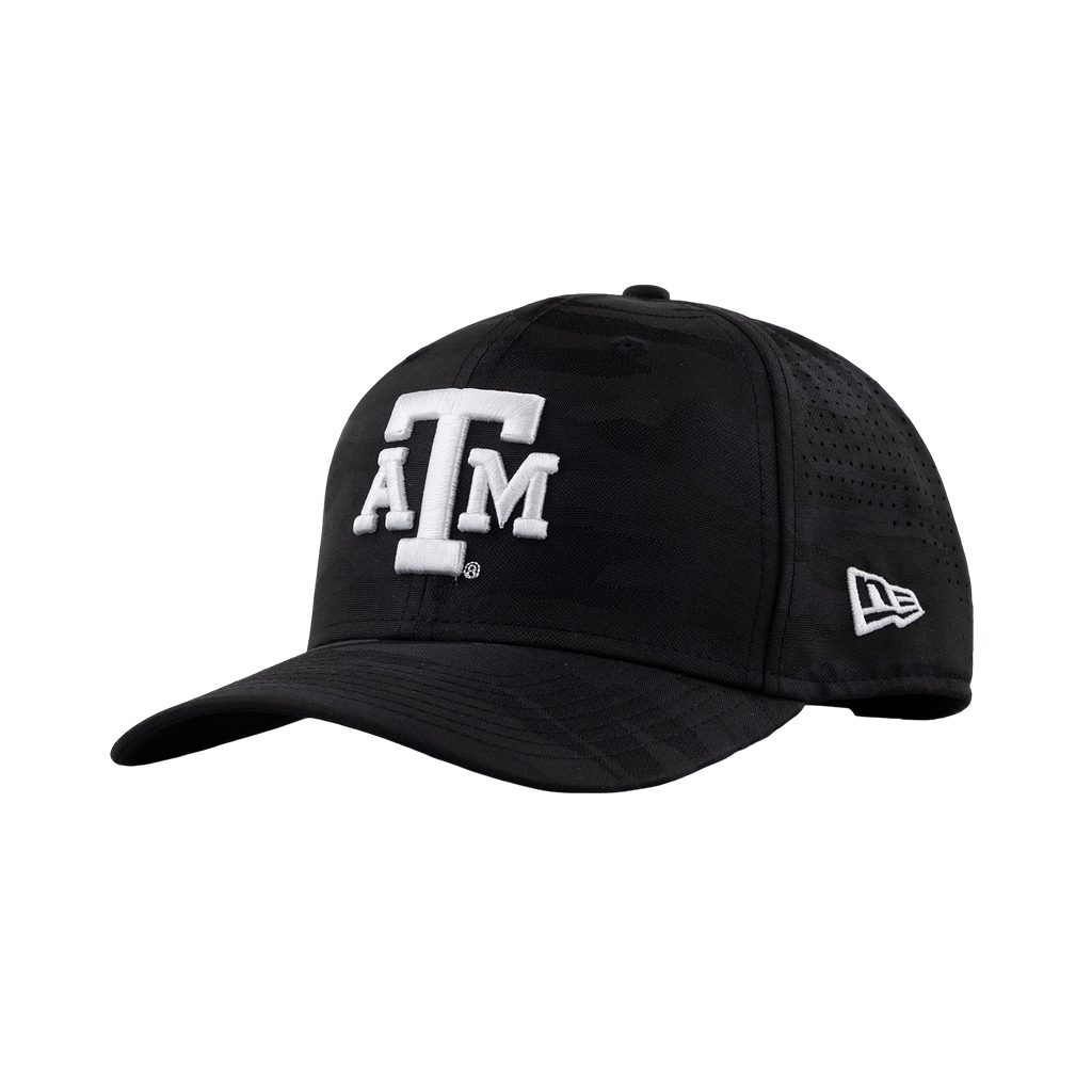 A black baseball cap with a subtle tonal camouflage pattern, featuring a white embroidered 'A&M' logo on the front and a white New Era logo on the side. The cap is shown from a three-quarter angle against a plain white background.