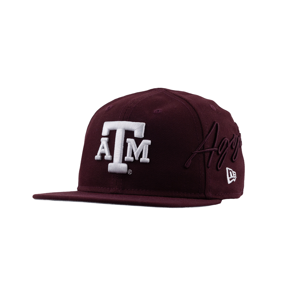 A maroon snapback cap featuring a white embroidered 'A&M' logo on the front, a maroon 'Aggies' script embroidery on the side, and a white New Era logo on the brim, set against a plain white background.