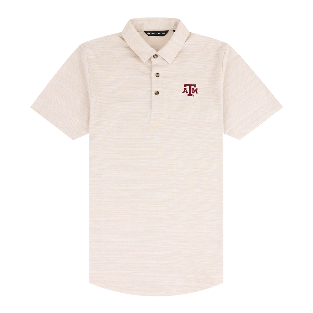 Travis Mathew cream polo with Texas A&M Lettering on the upper left chest.